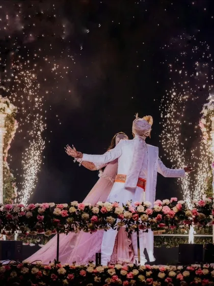 A close-up of the couple on stage, surrounded by sparklers, lost in their own world.