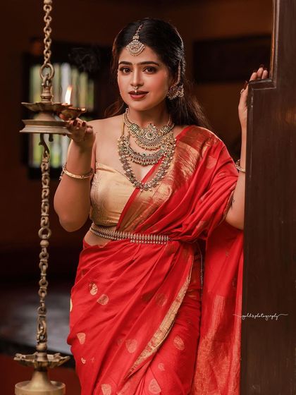 Capturing the bride in her element. Holding a traditional lamp, she is framed by the doorway of a heritage home, with the light creating a warm, inviting glow that speaks of tradition and hospitality.