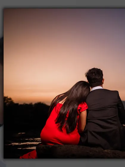 A quiet moment of togetherness, watching the day end. The warm colors of the sunset add a deep sense of romance to the scene.