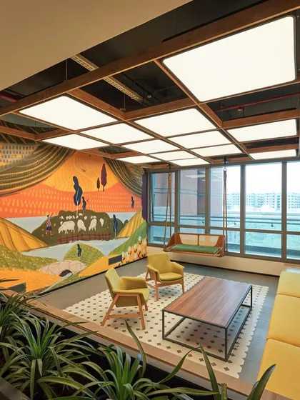 A beautiful breakout space with a large, pastoral-themed mural. The space includes comfortable seating and a swing, offering a peaceful escape.