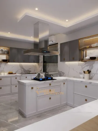 A bright and airy kitchen design featuring white and grey cabinets, a central island with a cooktop, and a striking stainless steel chimney. The marble countertops and backsplash tie the entire space together.