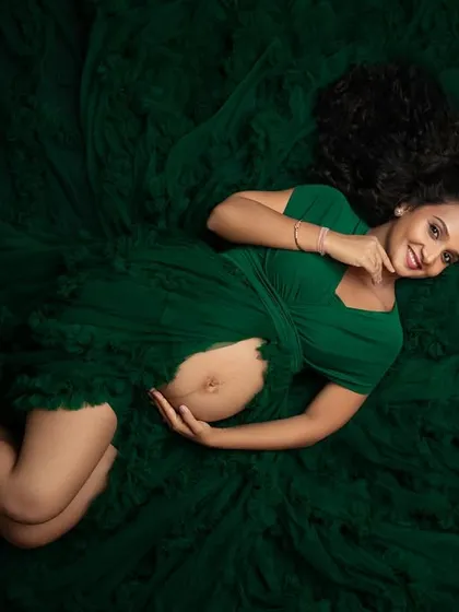 A joyful smile in this beautiful overhead shot. The contrast between her radiant expression and the deep green fabric makes this image truly captivating.