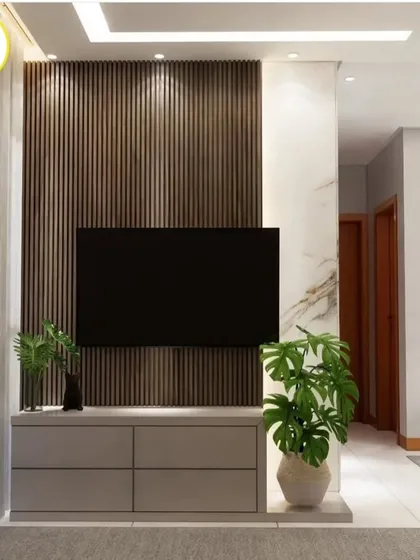 The TV unit is the star of this wall, with vertical wood slats and a sleek grey console. The design is clean, modern, and provides ample storage.