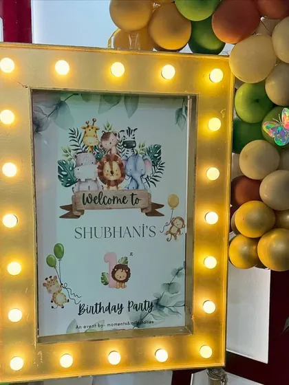A personalized welcome sign is a must. For this jungle party, we framed the sign with marquee lights to make it a standout feature at the entrance.