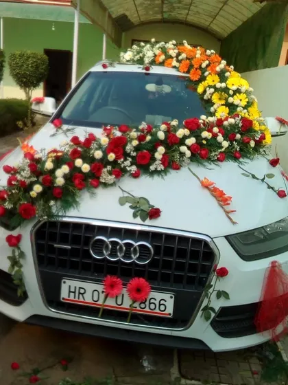 I provide premium flower decoration for all types of wedding cars. This Audi is decorated with a lush arrangement of red, white, and yellow flowers across the bonnet for a grand exit.