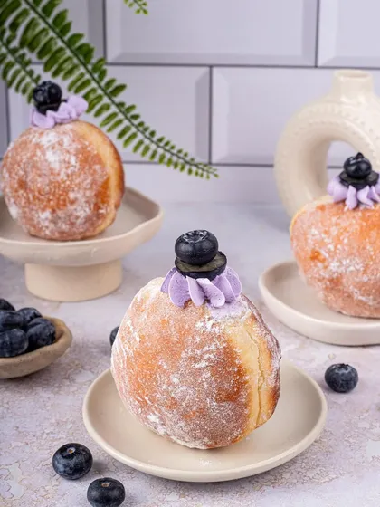 These blueberry bombolonis look like little clouds of sweetness. The light and airy styling with minimalist props puts all the focus on the fluffy donuts.