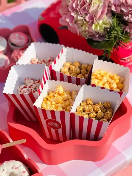 Another angle of the vibrant popcorn station, set against the pink floral centerpiece and themed decor of the Barbie party.