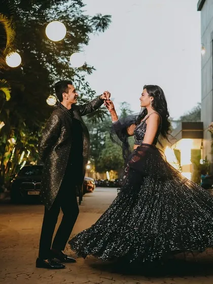 A glamorous twirl under the soft glow of evening lights. The bride's sparkling lehenga comes to life in this dynamic shot, perfect for a chic, modern engagement celebration with a touch of cinematic flair.
