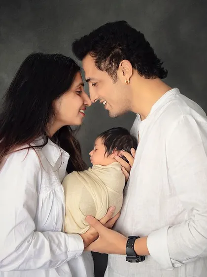 The beginning of a new family. This intimate portrait captures the pure love and happiness of new parents as they gaze at their precious newborn baby.