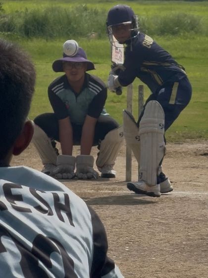 A tense moment in the match as the batsman prepares to face the bowler. The field is set and everyone is ready.