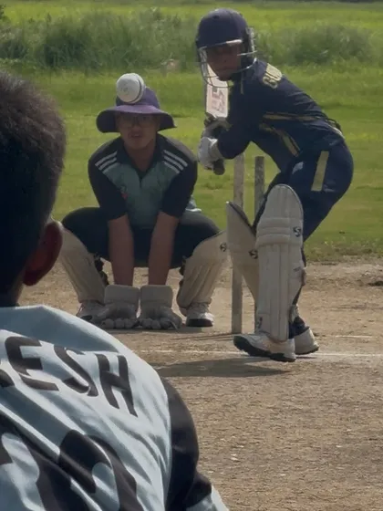 A tense moment in the match as the batsman prepares to face the bowler. The field is set and everyone is ready.