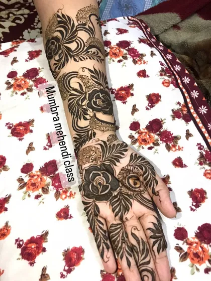 I just love how the leaves and roses intertwine in this full-arm design. It's a perfect example of organic, flowing mehendi art.