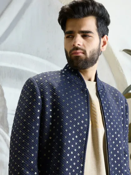 Elevated everyday style. This navy bomber jacket features a textured, quilted weave with subtle gold detailing, perfect for adding a touch of sophistication to a casual outfit.