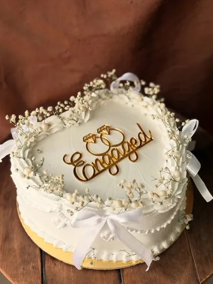 A side view of the elegant engagement cake, showing the detailed piping and the placement of the baby's breath.
