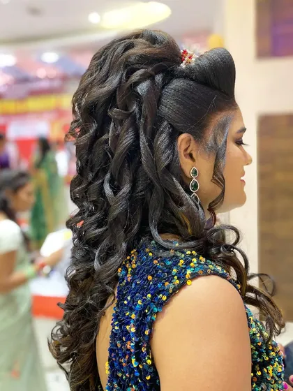 This is a high volume, open curl hairstyle ideal for a reception or cocktail party. The dramatic curls and side parting create a glamorous look that is sure to make a statement.
