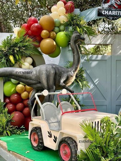 The birthday boy gets to ride in a custom Jurassic Park style jeep, placed next to a towering brachiosaurus prop.
