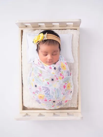Another beautiful floral swaddle from Haus and Kinder, this time with the baby posed in a simple wooden crib for a clean, modern look.
