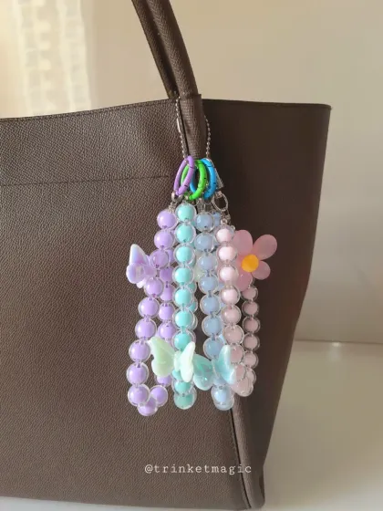 This multi-strand beaded charm adds so much personality to a simple tote bag. It features pastel purple, blue, and pink beads with delicate butterfly and flower charms for a dreamy, aesthetic look.
