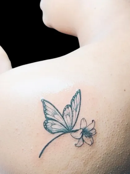 A dragonfly tattoo on the shoulder blade.