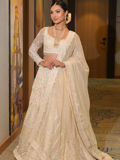 A full-length view of the ethereal white lehenga and the complementary makeup. This is a perfect example of a modern, elegant bridal look.