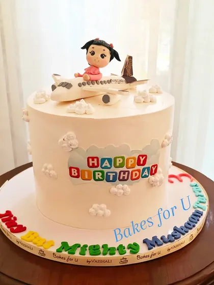 Another angle of the Vistara airplane cake, showing the colorful "Happy Birthday" message and fluffy buttercream clouds.