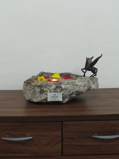 Placed on a wooden console, this natural stone bowl adds a touch of organic luxury to the room. It serves as a beautiful urli for floating decorations.