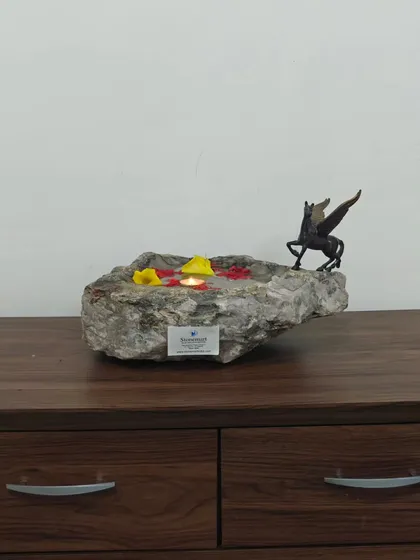 Placed on a wooden console, this natural stone bowl adds a touch of organic luxury to the room. It serves as a beautiful urli for floating decorations.