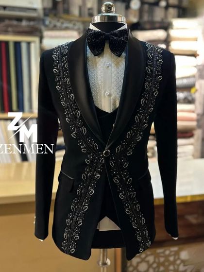 A full view of the black tuxedo with silver leaf embroidery. The design elegantly frames the torso, creating a flattering and sophisticated silhouette.