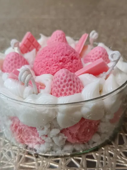 A highly detailed ice cream dessert candle with multiple scoops, strawberries, and chocolate bars.