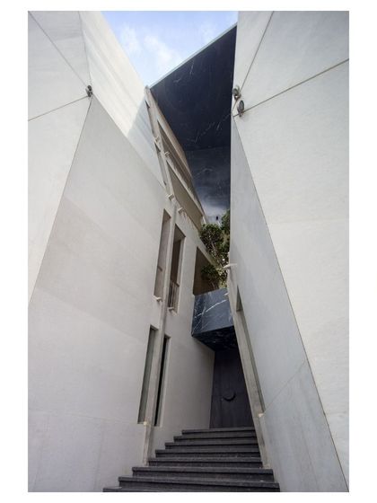 A detail of the Cleft House facade, showing the narrow, canyon-like entrance that leads into the heart of the home. This design choice enhances privacy while creating a dramatic sense of arrival.