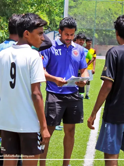 A close-up of a coach reviewing player performance notes during the international trials. I conduct a meticulous selection process to identify players with the most potential.