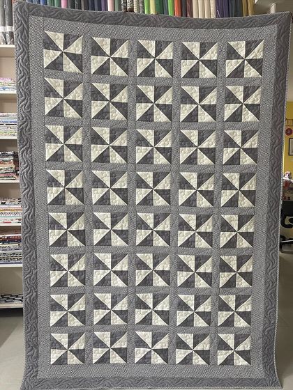 A classic Pinwheel quilt in a sophisticated grey and white palette.