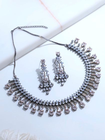 A flat lay of the black rhodium necklace and earrings. This view highlights the contrast between the sparkling fancy-cut diamonds and the dark, modern finish of the rhodium.