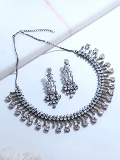 A flat lay of the black rhodium necklace and earrings. This view highlights the contrast between the sparkling fancy-cut diamonds and the dark, modern finish of the rhodium.