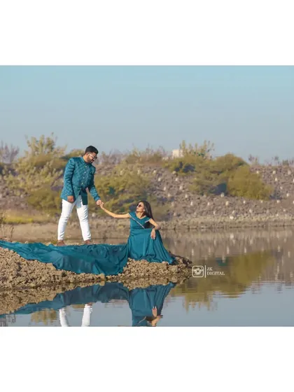 A beautiful reflection shot of the couple by the water's edge. The long, flowing trail of the gown adds a touch of elegance and drama to this lakeside pre-wedding photo.