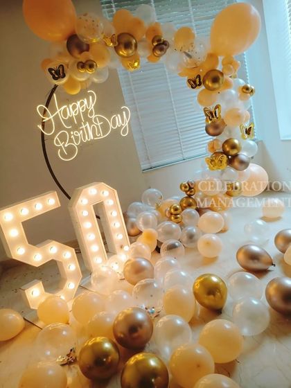The butterfly accents scattered throughout the balloon arch add a delicate and whimsical touch to this milestone celebration.