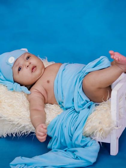Just relaxing. This little one is chilling in his miniature bed, looking cool and content in his blue wrap.