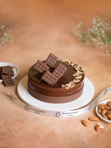 This Chocolate Almond cake is all about texture. A rich chocolate cake is covered in a glossy ganache and topped with crunchy almond slivers and decorative chocolate bars.