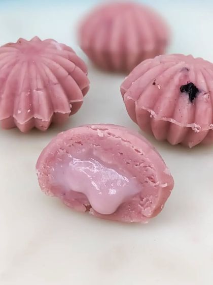 The Blueberry Cake Mithai offers a burst of fruity flavor, with a sweet and tangy blueberry filling encased in a beautiful shell-shaped sweet.