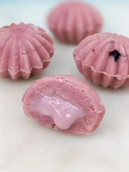 The Blueberry Cake Mithai offers a burst of fruity flavor, with a sweet and tangy blueberry filling encased in a beautiful shell-shaped sweet.