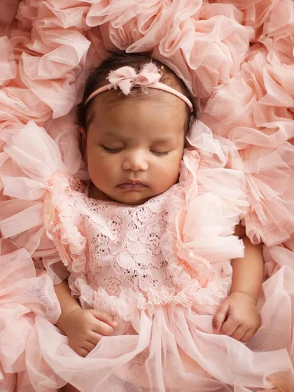 Look at this little princess! I have a collection of beautiful, soft outfits and props, like this delicate pink lace romper and ruffled backdrop, to make your baby girl's first portraits absolutely magical.