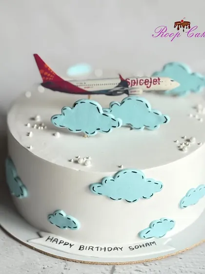 A half-kg cake for an aviation enthusiast, featuring a SpiceJet airplane flying through fluffy clouds.