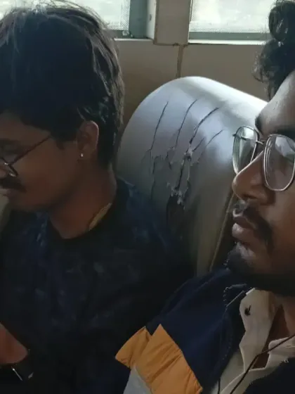 Two young seekers from our group resting during the bus journey to the Kumbh. The pilgrimage can be tiring, and these quiet moments are part of the experience.
