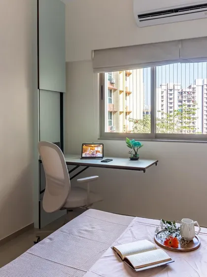 This bedroom features a sleek, wall-mounted desk by the window, creating a perfect work-from-home spot that doesn't take up valuable floor space.