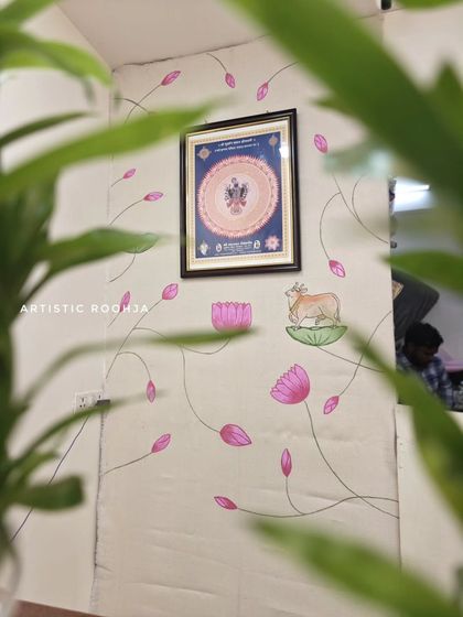 A wider view of the Pichwai mural, showing how the artwork flows around a framed picture of Shrinath ji. The climbing lotus vines create a sense of peace and devotion.