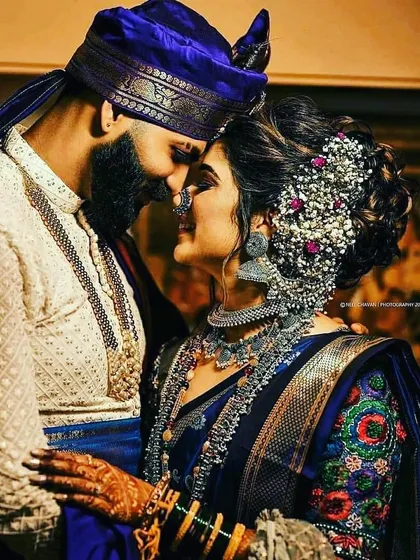 We also specialize in regional wedding styles, like this stunning Maharashtrian couple. The bride's royal blue Paithani-style saree and traditional silver jewelry are paired with the groom's white kurta and royal blue turban. We can help you find authentic regional occasion wear for rent.
