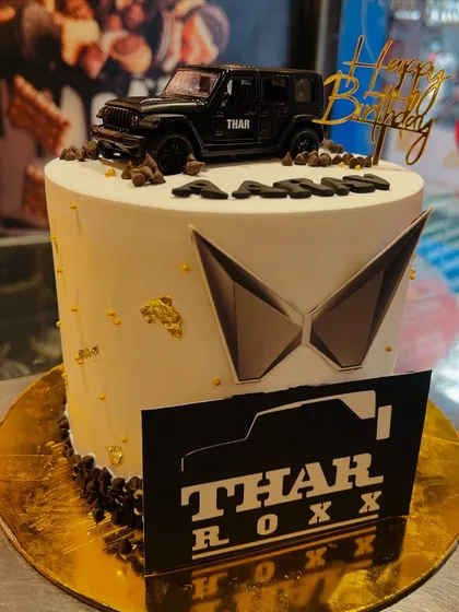The perfect birthday cake for a Thar enthusiast. This design features a miniature Thar model, the Mahindra logo, and a personalized name, making it a unique and memorable centerpiece.