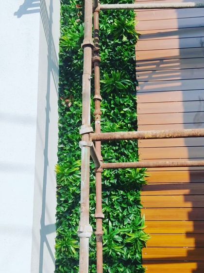 This image shows an exterior green wall being installed next to wood paneling. The scaffolding shows that I can handle installations on multi-story buildings.