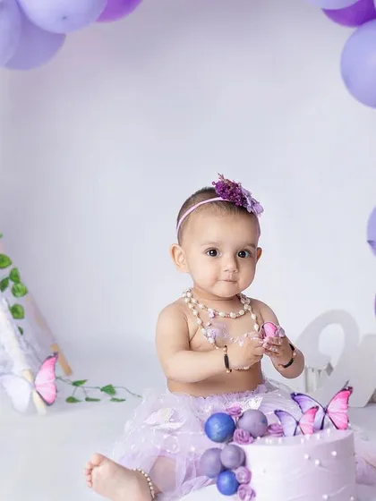 A butterfly-themed cake smash for a sweet one-year-old. The purple and pink colors create such a pretty and delicate scene.