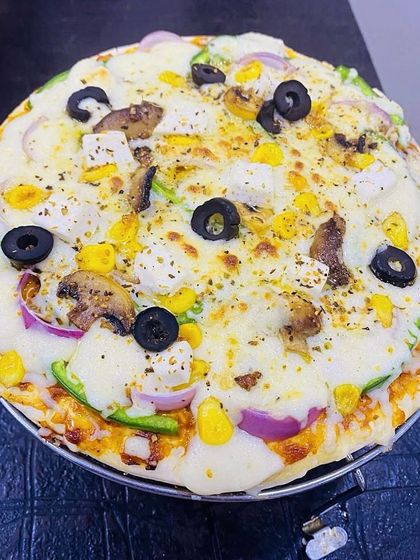 My special homemade vegetable pizza, loaded with cheese, olives, corn, mushrooms, and other fresh veggies. It's a big hit at birthday parties.
